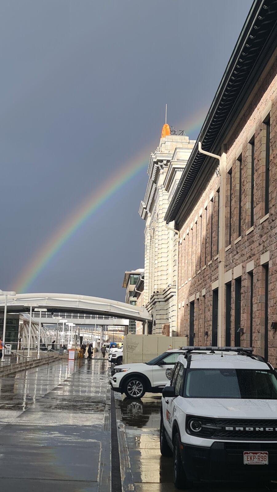 Rainbow over a rain-soaked city street