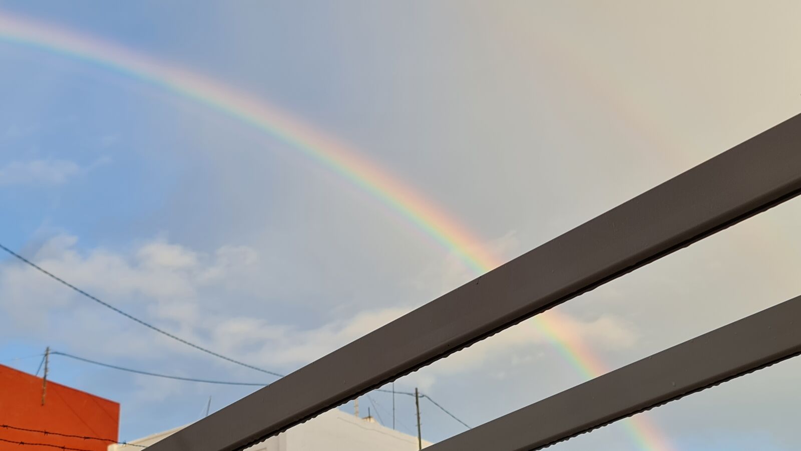 Rainbow arcing over rooftops